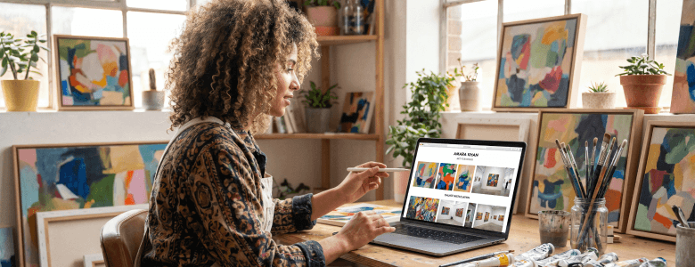 Independent artist showcasing artwork portfolio online in a creative home studio
